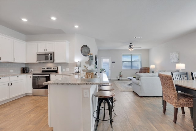 kitchen featuring white cabinets, appliances with stainless steel finishes, sink, and light wood-type flooring