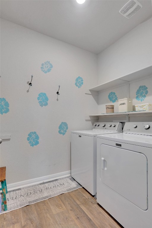 clothes washing area featuring light hardwood / wood-style floors and independent washer and dryer