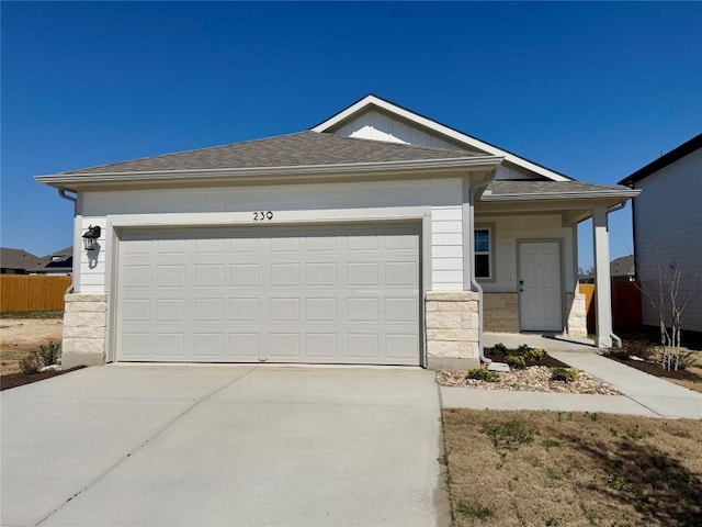 239 Hidalgo Ln, Elgin, TX 78621 - ranch-style home featuring driveway, stone siding, a garage, and a shingled roof