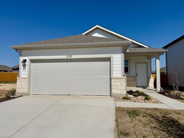 239 Hidalgo Ln, Elgin, TX 78621 - view of front facade featuring concrete driveway, stone siding, and a garage