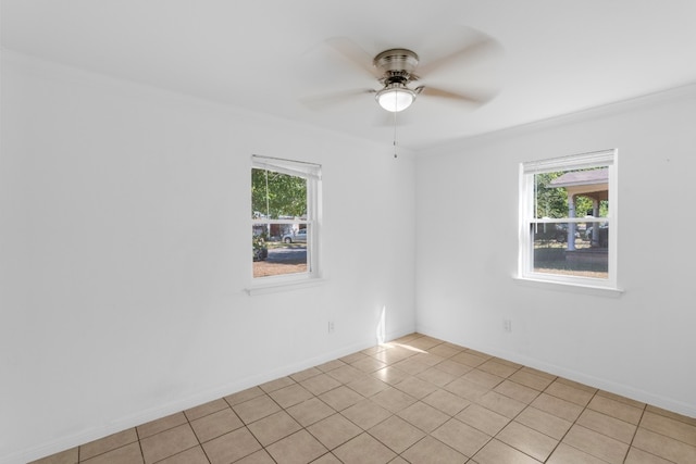 spare room featuring a healthy amount of sunlight, light tile patterned flooring, and ceiling fan