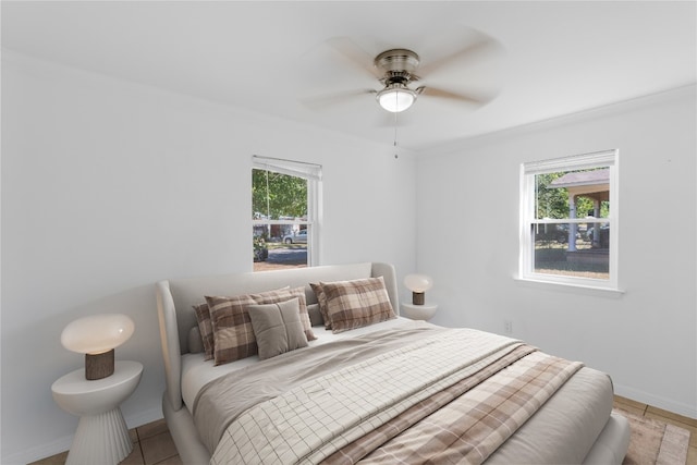 bedroom featuring ceiling fan, crown molding, and multiple windows