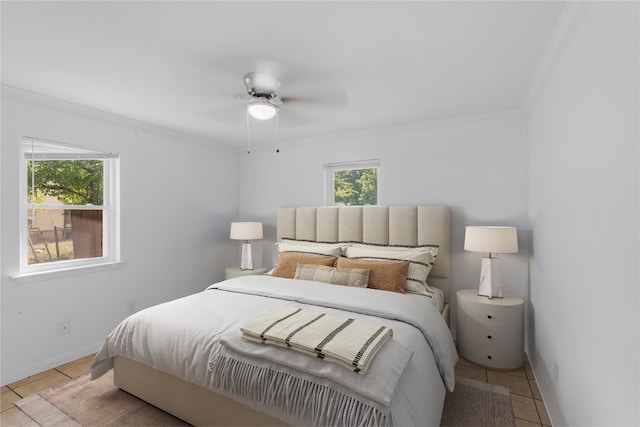 bedroom featuring ceiling fan, crown molding, multiple windows, and light tile patterned floors