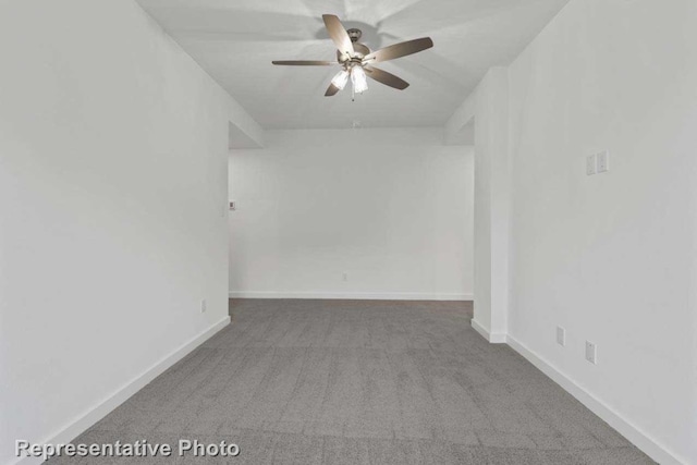 spare room with ceiling fan and carpet