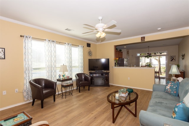 living room featuring crown molding, ceiling fan, and light wood-type flooring