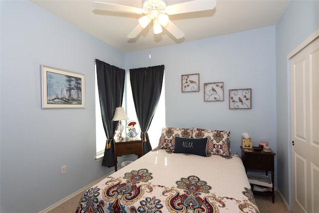 carpeted bedroom featuring ceiling fan and a closet