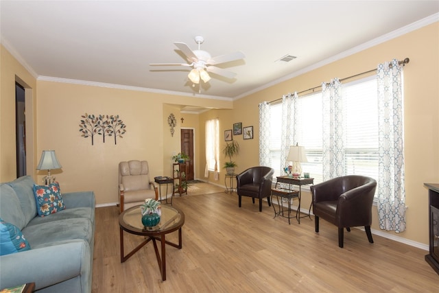 living room with crown molding, ceiling fan, and light hardwood / wood-style floors