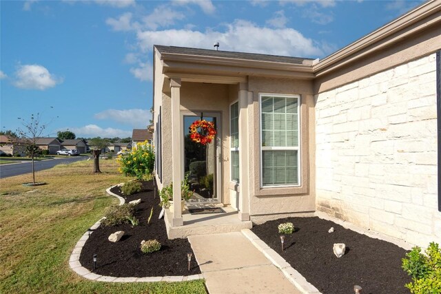 entrance to property with a lawn