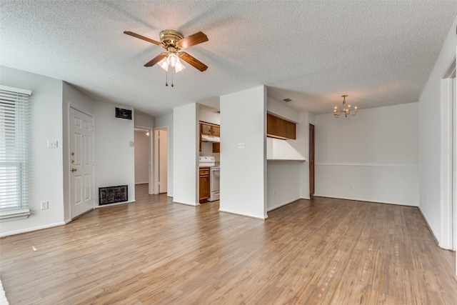 unfurnished living room featuring ceiling fan with notable chandelier, light hardwood / wood-style flooring, and a textured ceiling