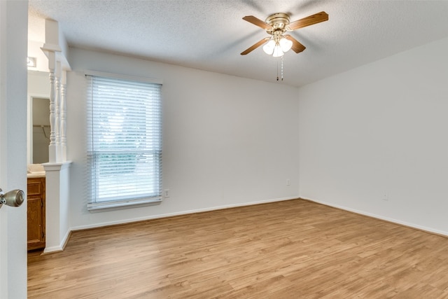 spare room featuring ceiling fan, light hardwood / wood-style flooring, and a textured ceiling