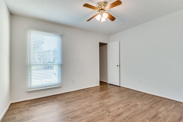 10616 Mellow Mdws Unit 9D, Austin, TX 78750 - spare room featuring baseboards, a ceiling fan, and wood finished floors