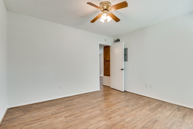 empty room featuring ceiling fan, light hardwood / wood-style floors, and a textured ceiling