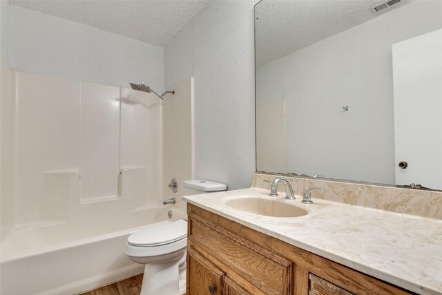 10616 Mellow Mdws Unit 9D, Austin, TX 78750 - full bath with wood finished floors, visible vents, toilet, vanity, and a textured ceiling