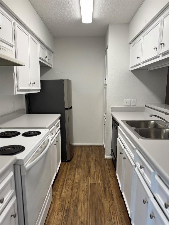 kitchen featuring dark wood-style floors, white range with electric stovetop, light countertops, a sink, and a textured ceiling