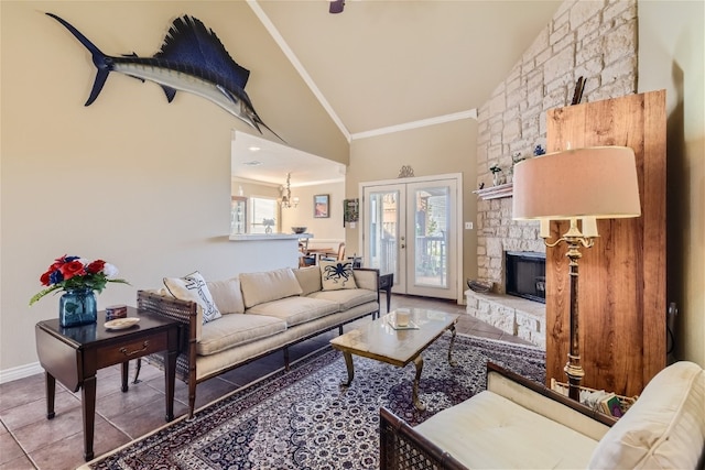 living room with tile patterned floors, a stone fireplace, vaulted ceiling, crown molding, and a chandelier