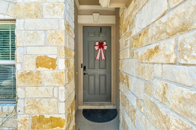 view of exterior entry featuring stone siding