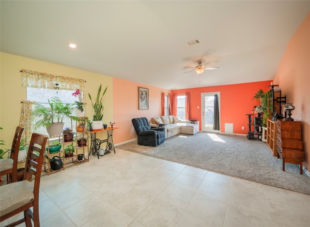 carpeted living room with ceiling fan