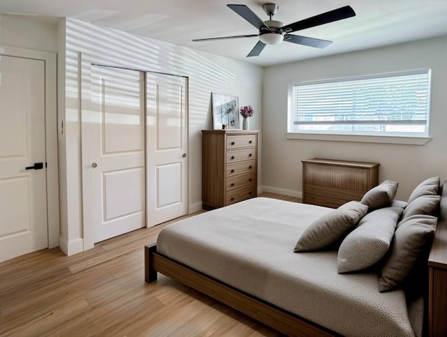 bedroom featuring ceiling fan, light hardwood / wood-style floors, and a closet