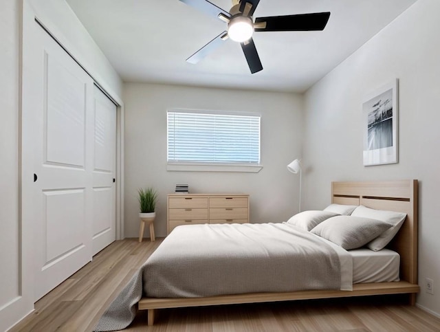 bedroom with ceiling fan, a closet, and light hardwood / wood-style flooring