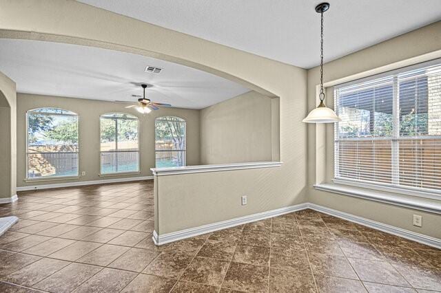 tiled spare room featuring ceiling fan