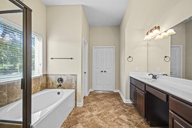 bathroom with vanity and a washtub