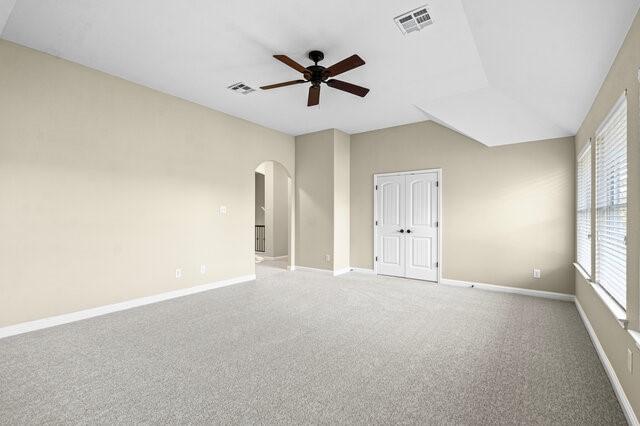 spare room with ceiling fan, lofted ceiling, and carpet flooring