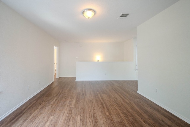 empty room with dark hardwood / wood-style flooring