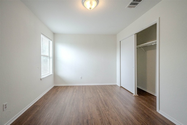 unfurnished bedroom featuring a closet and dark hardwood / wood-style floors