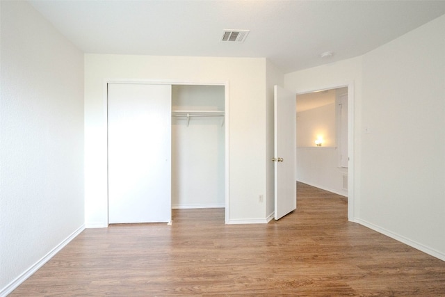 unfurnished bedroom with a closet and light hardwood / wood-style floors