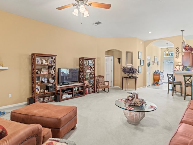 living room with light carpet and ceiling fan with notable chandelier