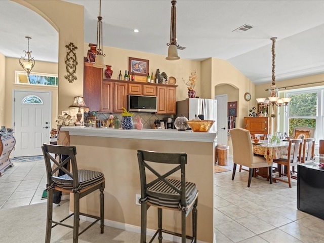 kitchen featuring a breakfast bar area, pendant lighting, and stainless steel appliances