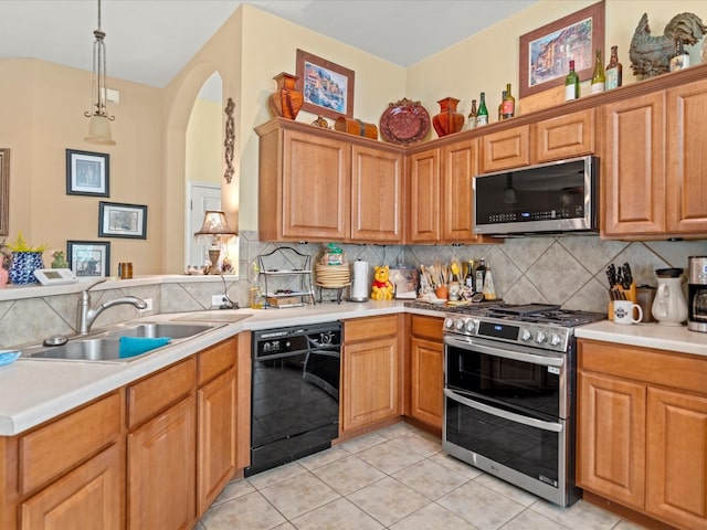 kitchen featuring appliances with stainless steel finishes, light tile patterned flooring, sink, backsplash, and decorative light fixtures