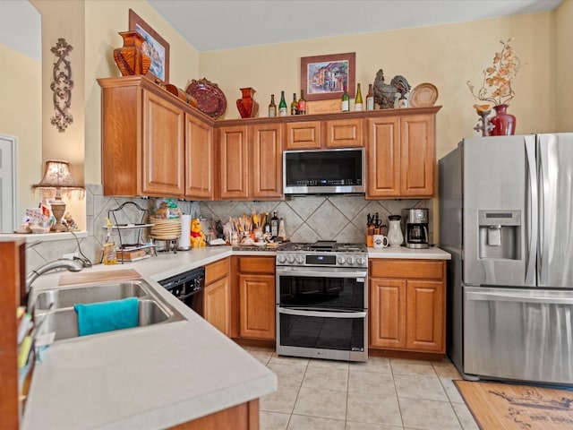 kitchen with sink, appliances with stainless steel finishes, light tile patterned floors, and tasteful backsplash