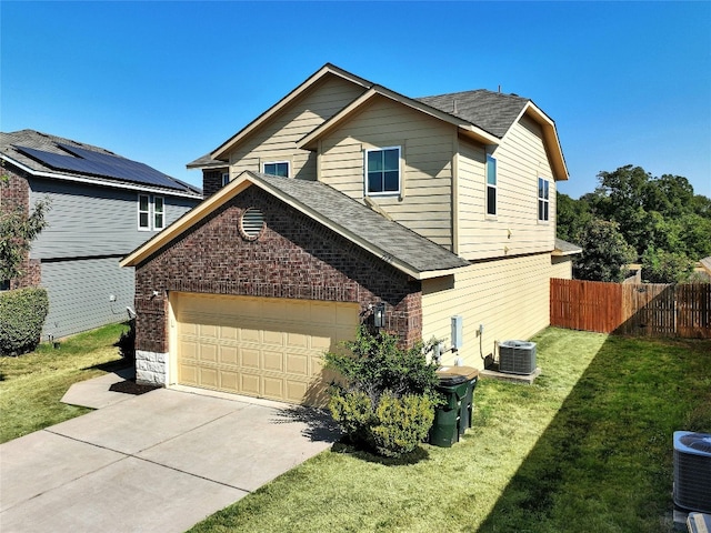 view of front of house with a garage, a front lawn, and central AC unit