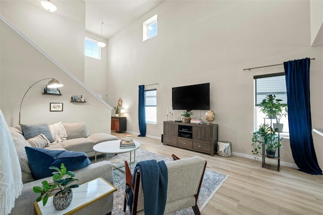 living room featuring light hardwood / wood-style flooring and a towering ceiling