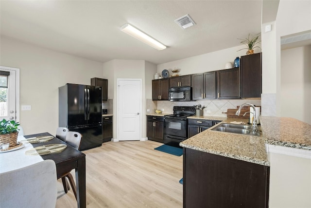 kitchen featuring black appliances, sink, light wood-type flooring, backsplash, and dark brown cabinets