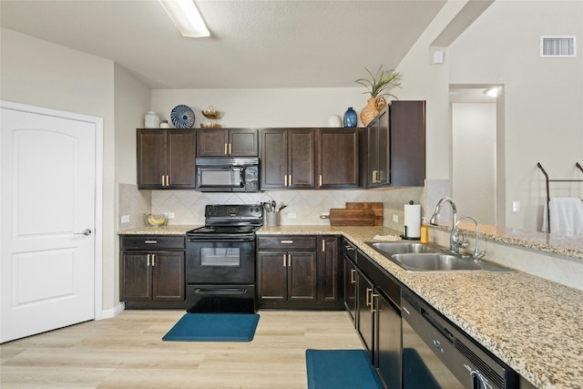 kitchen with backsplash, sink, black appliances, dark brown cabinetry, and light wood-type flooring