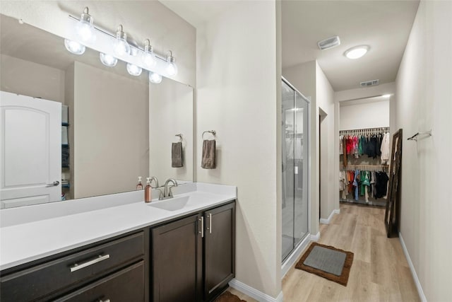 bathroom with vanity, wood-type flooring, and walk in shower