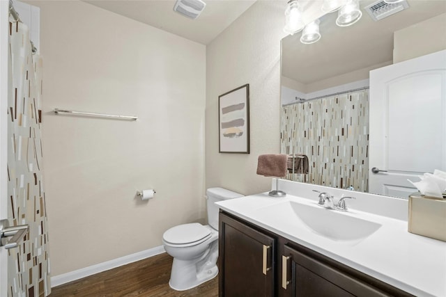 bathroom featuring vanity, hardwood / wood-style floors, toilet, and walk in shower