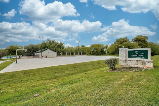 view of property's community featuring basketball court and a lawn