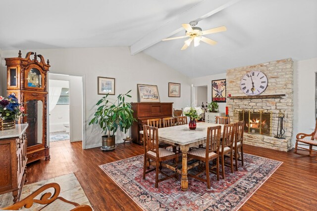 dining space featuring ceiling fan, lofted ceiling with beams, a fireplace, and dark hardwood / wood-style floors