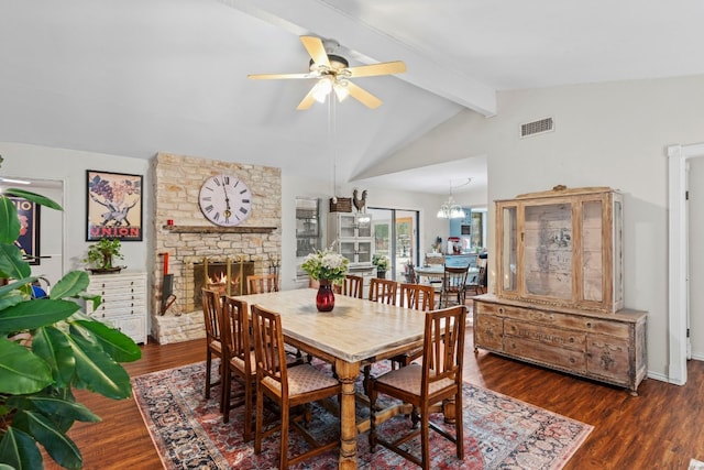 dining area with dark wood-type flooring, a fireplace, vaulted ceiling with beams, and ceiling fan with notable chandelier