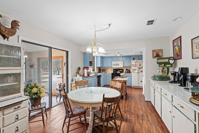 dining space featuring dark hardwood / wood-style floors and an inviting chandelier