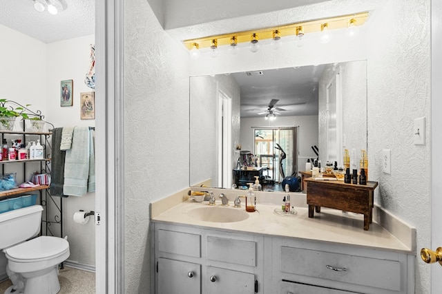 bathroom with vanity, a textured ceiling, toilet, and ceiling fan