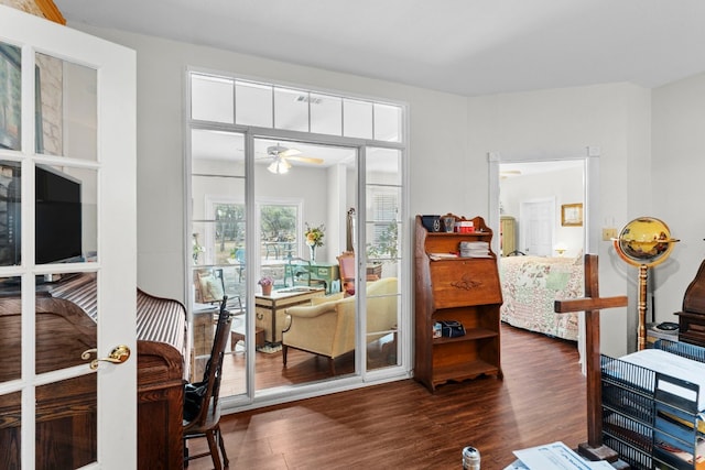 living area featuring french doors, ceiling fan, and dark hardwood / wood-style flooring