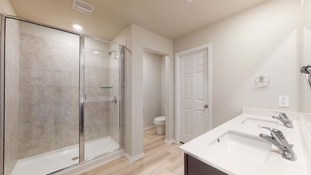 bathroom featuring vanity, hardwood / wood-style floors, toilet, and walk in shower