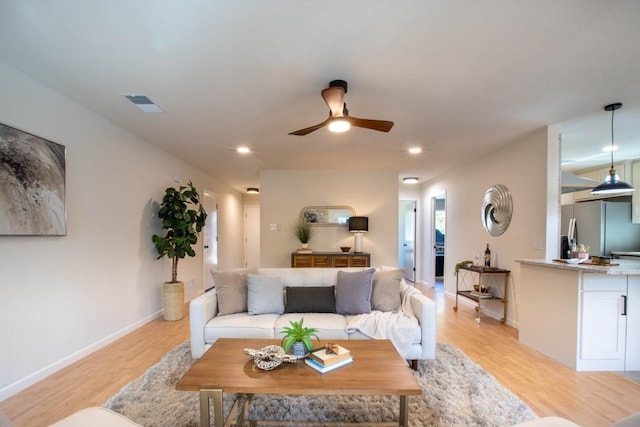 living room featuring ceiling fan and light hardwood / wood-style floors