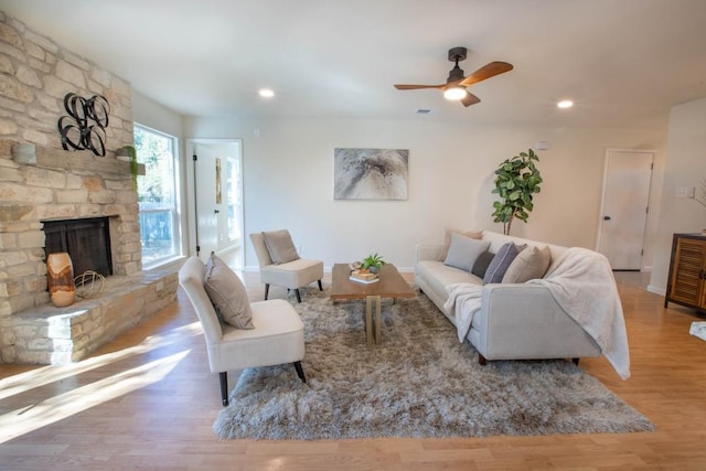 living room featuring hardwood / wood-style flooring and a stone fireplace