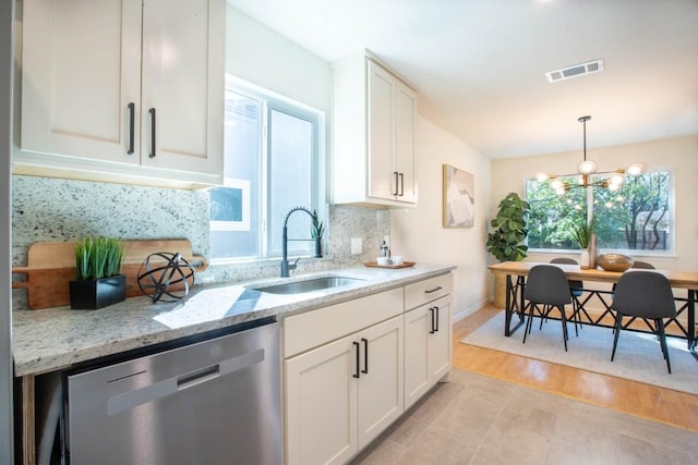 kitchen with sink, light stone counters, dishwasher, decorative backsplash, and white cabinets