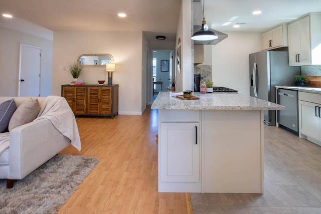 kitchen with white cabinetry, stainless steel dishwasher, light stone countertops, and hanging light fixtures